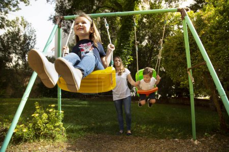 Téléchargez les photos : Les enfants jouent sur une balançoire - en image libre de droit