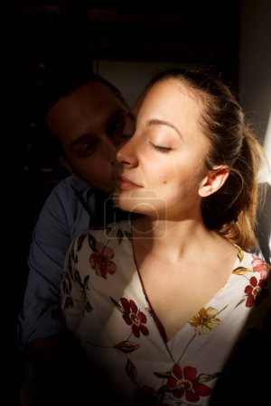Téléchargez les photos : Portrait d'un jeune homme avec une jeune femme dans la cuisine au coucher du soleil. - en image libre de droit