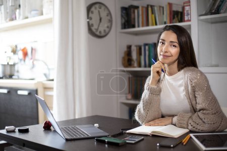 Photo for Brunette girl works at the computer at home - Royalty Free Image