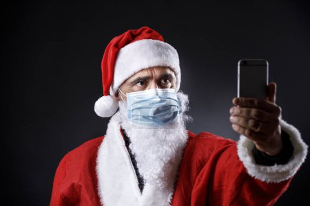 Téléchargez les photos : Homme en costume de Père Noël portant un masque - en image libre de droit