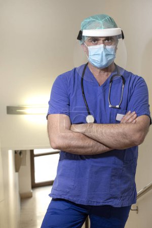 Téléchargez les photos : Médecin avec protection chirurgicale et blouse bleue isolée sur fond blanc - en image libre de droit