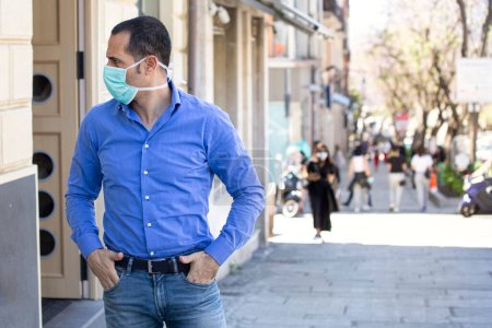 Photo for Man with blue shirt, face mask is firm in urban context - Royalty Free Image