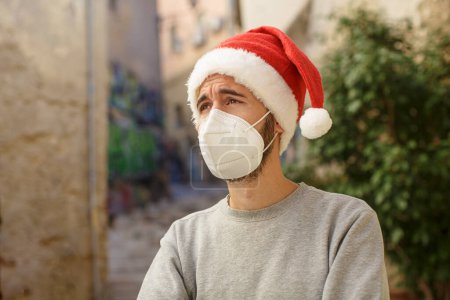 Photo for Young man wearing santa claus mask and hat outdoors - Royalty Free Image