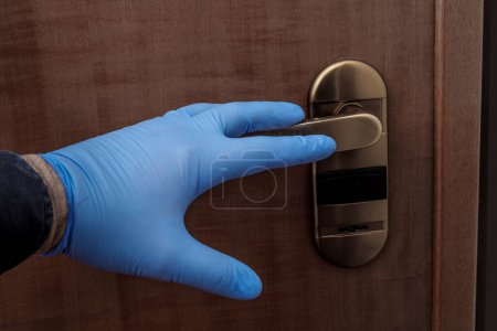 Photo for Hand with protective glove opens a small door - Royalty Free Image