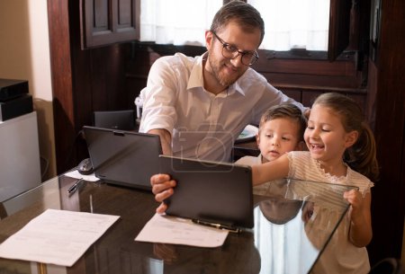 Téléchargez les photos : Père avec enfants utilisant une tablette numérique - en image libre de droit