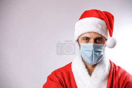 Téléchargez les photos : Père Noël avec masque chirurgical, isolé sur fond blanc - en image libre de droit