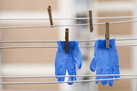 Photo for Blue latex gloves, stretched in the threads with the clothespins to dry - Royalty Free Image