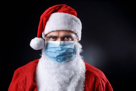 Photo for Man in santa costume wearing mask - Royalty Free Image