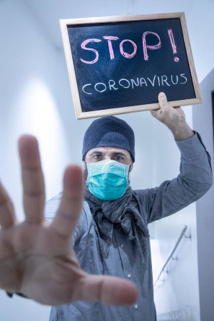 Téléchargez les photos : Homme brun en costume avec un masque antivirus, montre un signe contre la couronne du virus - en image libre de droit