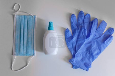 Téléchargez les photos : Masque chirurgical, gants en latex et spray antibactérien isolé sur fond blanc - en image libre de droit