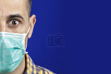 Photo for Portrait of shaved man with plaid shirt facial mask with serious expression, isolated on blue background - Royalty Free Image