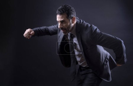 Foto de Gerente en traje elegante corre rápidamente aislado sobre fondo negro - Imagen libre de derechos