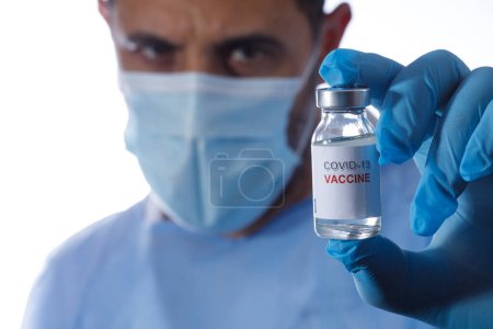 Photo for Man with surgical mask, protectors and latex gloves is holding a vial of anti-covid vaccine, isolated on white background - Royalty Free Image