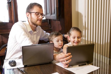 Foto de Padre con niños usando la tableta en casa - Imagen libre de derechos