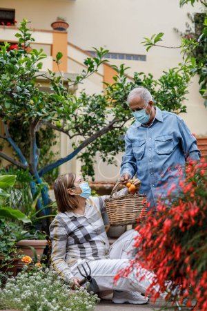 Téléchargez les photos : Couple âgé dans le jardin à la maison - en image libre de droit