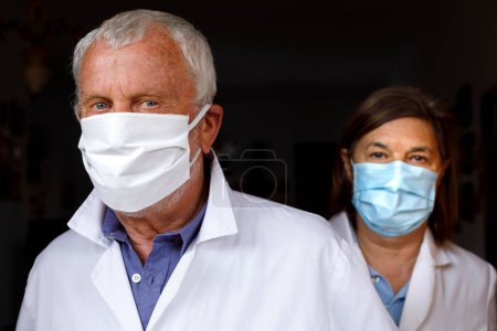 Téléchargez les photos : Médecin et assistant dans les masques de protection - en image libre de droit