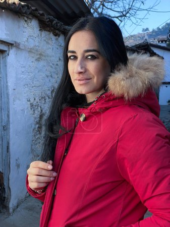 Téléchargez les photos : Portrait d'une jeune femme en veste rouge posant à l'extérieur - en image libre de droit