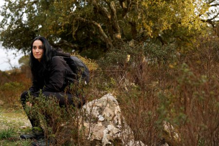 Foto de Mujer con una mochila descansando en el bosque - Imagen libre de derechos