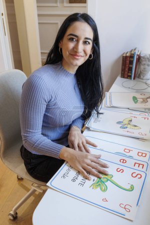 Foto de Educadora en su estudio profesional compone la escritura "BES" (necesidades educativas especiales) con letras en papel - Imagen libre de derechos