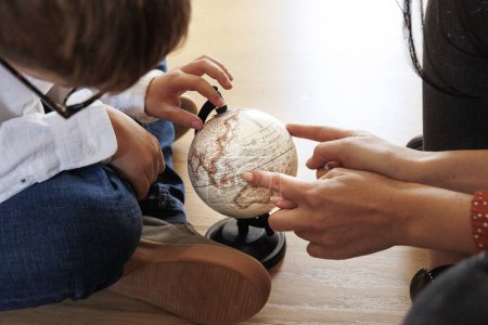 Photo for Detail of a globe with two hands in the foreground indicating geographical places - Royalty Free Image