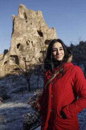 Téléchargez les photos : Jeune belle femme en veste rouge posant dans un beau paysage de la cappadoce. - en image libre de droit