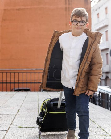 Photo for Young student with his trolley of books is preparing to go to school - Royalty Free Image