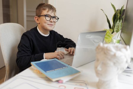 Foto de Estudiante sentado en frente de su escritorio utiliza su computadora - Imagen libre de derechos