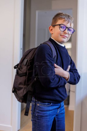 Téléchargez les photos : Blond garçon avec des lunettes et routard croise les bras dans sa chambre - en image libre de droit