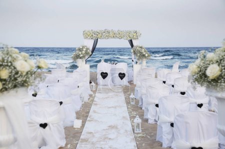 Téléchargez les photos : Cérémonie de mariage sur une plage avec vue sur la mer. - en image libre de droit