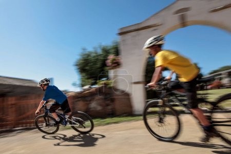 Téléchargez les photos : Cyclistes dans le centre historique de San Giovanni Suergiu - Sardaigne - Italie - en image libre de droit