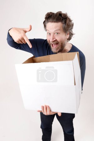 hombre feliz apuntando a la caja que recibe.studio disparar