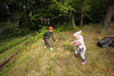 Frère avec sa petite sœur jouer dans la forêt d'automne attraper et lancer jeu de balle.