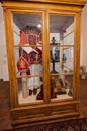Foto de Rajhrad, República Checa - 22 de mayo de 2022: Ropa sacerdotal y cruz en el armario en el museo del monasterio en Rajhra - Imagen libre de derechos