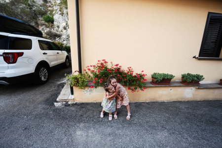 Foto de Dos hermanas abrazos cerca de casa en Nocera Umbra, ciudad y municipio en la provincia de Perugia, Italia. - Imagen libre de derechos