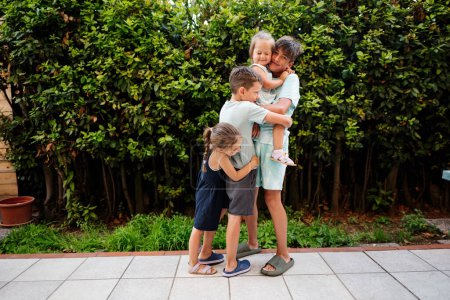 Téléchargez les photos : Quatre enfants heureux sur la terrasse de la maison. Frères et sœurs. - en image libre de droit