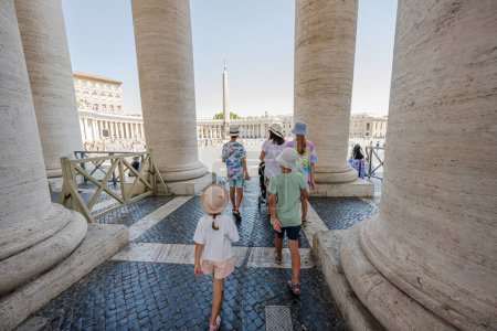 Foto de Familia caminando unde columnata cerca de la Basílica de San Pedro iglesia en la ciudad del Vaticano. - Imagen libre de derechos
