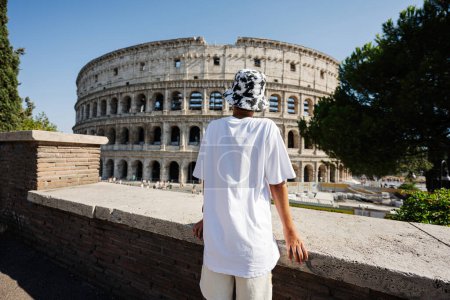 Téléchargez les photos : Retour de garçon touriste profiter de la vue Colisée dans le centre-ville de Rome, Italie. - en image libre de droit