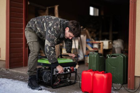 Foto de Ropa de hombre en chaqueta militar con gasolina portátil generador de reserva móvil. - Imagen libre de derechos