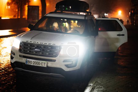 Téléchargez les photos : Ternopil, Ukraine- décembre, 24, 2022 : Ford Explorer with Thule Motion XT XXL Rooftop Cargo Box in evening street. - en image libre de droit