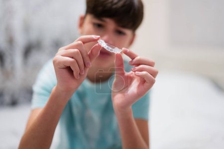 Teenager Jungen tragen Simulator kieferorthopädischen Silikon unsichtbare Nivellierspangen für die Zähne. Zahnkonzept, Kieferorthopädie. 
