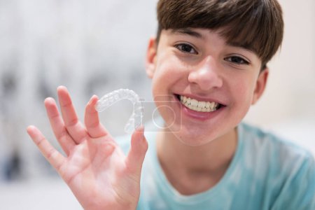 Téléchargez les photos : Teenager boy wear simulator orthodontic silicone invisible leveling braces for teeth.  Dental concept, orthodontics. - en image libre de droit