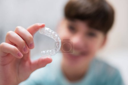 Photo for Teenager boy wear simulator orthodontic silicone invisible leveling braces for teeth.  Dental concept, orthodontics. - Royalty Free Image