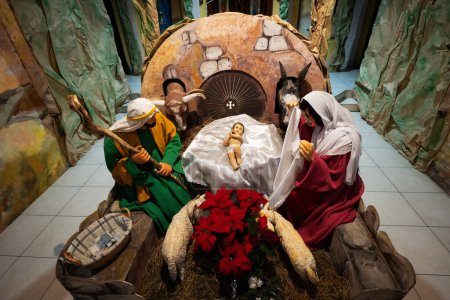 Foto de Christmas nativity crib scene in church. Stable with baby Jesus in a manger, Mary and Joseph. - Imagen libre de derechos