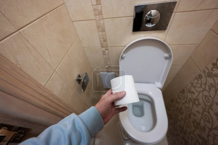 Photo for Man hand using toilet paper. - Royalty Free Image