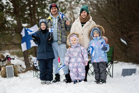 Famille finlandaise avec drapeaux Finlande par une belle journée d'hiver. Peuple scandinave nordique. 