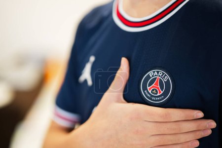 Téléchargez les photos : Ternopil, Ukraine - February, 2023: Boy put hand on heart, wear of PSG Paris Saint Germain football club uniform. - en image libre de droit