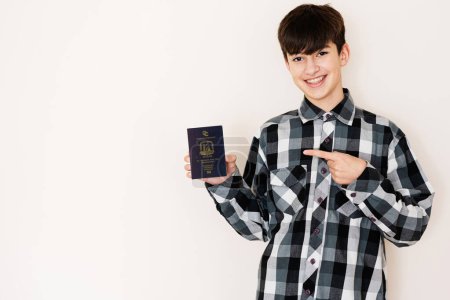 Foto de Young teenager boy holding Saint Vincent and the Grenadines passport looking positive and happy standing and smiling with a confident smile against white background. - Imagen libre de derechos