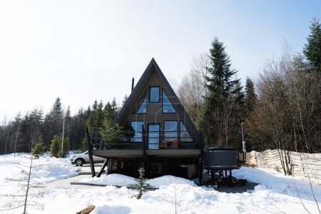 Holzdreieck Land winzige Hütte mit Whirlpool und Geländewagen mit Dachgepäckträger in den Bergen. Seelenwochenenden.