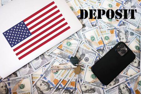 Foto de Concepto de depósito. Bandera de EE.UU., dinero en dólares con llaves, computadora portátil y fondo del teléfono. - Imagen libre de derechos