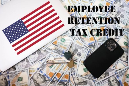 Photo for Employee retention tax credit concept. USA flag, dollar money with keys, laptop and phone background. - Royalty Free Image